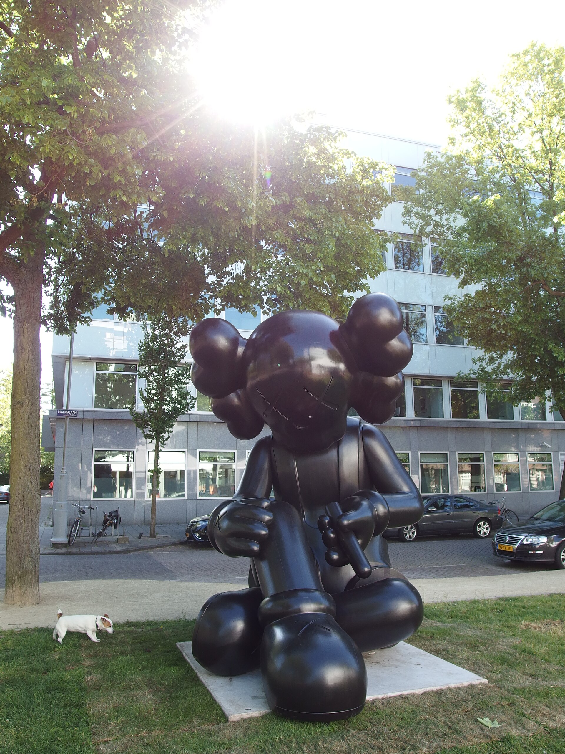 Sculpture « Better Knowing » de KAWS, un Companion noir aux yeux en croix, exposée dans une rue d’Amsterdam en 2015